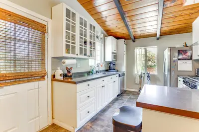 a kitchen with white cabinets and a wooden ceiling at Peaceful Vista House with Gas Grill 1 Mi to Dtwn! in Vista