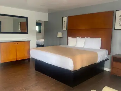 a hotel room with a large bed and a mirror at Oceanside Inn & Suites in Oceanside