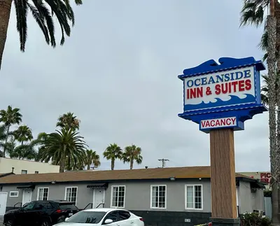 a sign for a localensible inn and suites at Oceanside Inn & Suites in Oceanside
