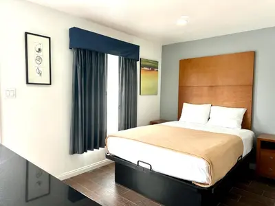 a bedroom with a large bed and a window at Oceanside Inn & Suites in Oceanside