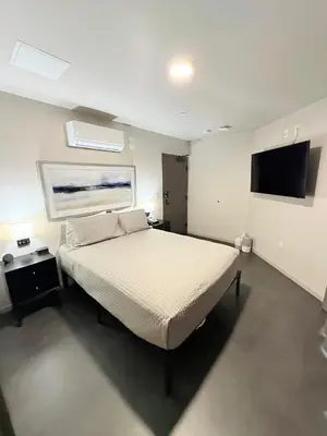 a bedroom with a bed and a flat screen tv at City24 Condo Hotel Little Italy Mission Hills in San Diego