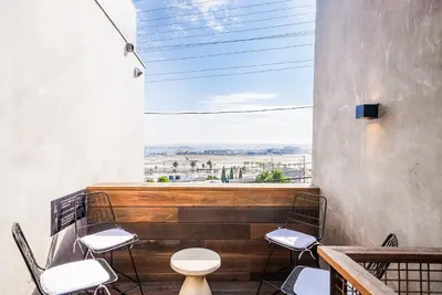 a balcony with a table and chairs and a window at City24 Condo Hotel Little Italy Mission Hills in San Diego
