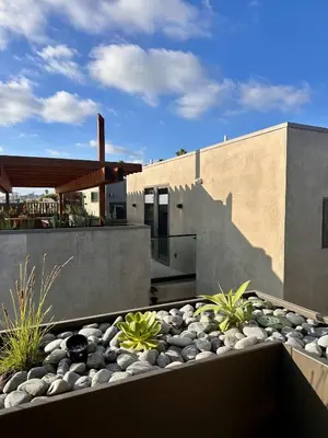 a house with a landscaping with rocks and a building at City24 Condo Hotel Little Italy Mission Hills in San Diego