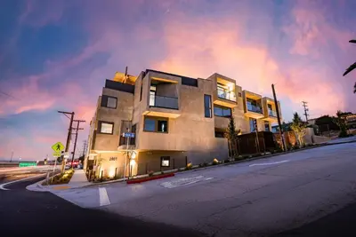 a building on the side of a street at night at City24 Condo Hotel Little Italy Mission Hills in San Diego