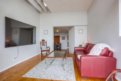 a living room with a red couch and a table at Steps 2 Ocean & Surfing Ocean Views Rooftop Deck in San Diego
