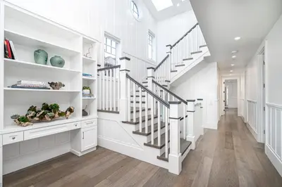 a white staircase in a home with white walls and wooden floors at 1225 W Balboa Blvd B in Newport Beach