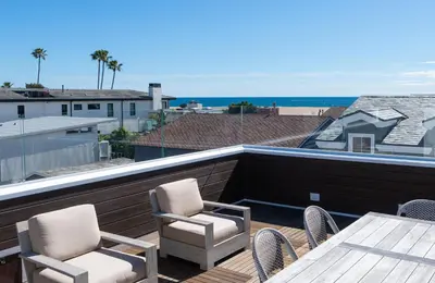 a balcony with chairs and a table and a view of the ocean at 1225 W Balboa Blvd B in Newport Beach