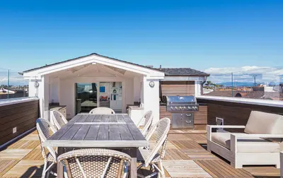 a deck with a wooden table and chairs on a roof at 1225 W Balboa Blvd B in Newport Beach