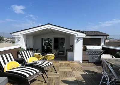 a patio with chairs and a grill on a deck at 1225 W Balboa Blvd B in Newport Beach