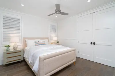 a white bedroom with a bed and a ceiling fan at 1225 W Balboa Blvd B in Newport Beach