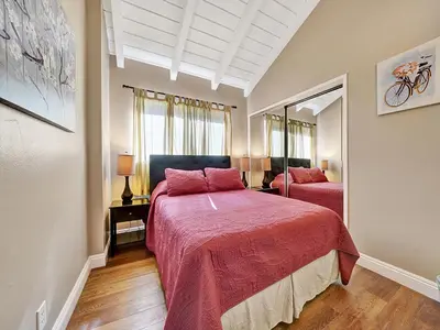 a bedroom with two beds with red sheets at 3607 Seashore A & B in Newport Beach