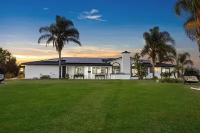a white house with palm trees and a lawn at Grenache Estate - Nestled in Temecula Wine Country in Temecula