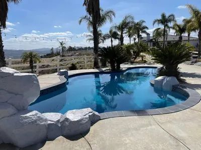a large swimming pool with rocks around it at Grenache Estate - Nestled in Temecula Wine Country in Temecula