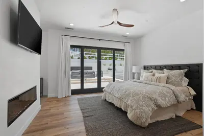a white bedroom with a bed and a tv at Villa Rosa in Temecula
