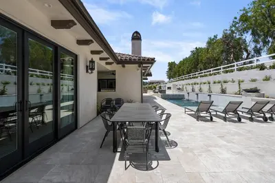 a patio with a table and chairs next to a pool at Villa Rosa in Temecula