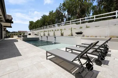 a group of benches sitting next to a swimming pool at Villa Rosa in Temecula