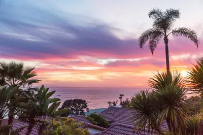 a palm tree and the ocean at sunset at Casa Laguna Hotel & Spa in Laguna Beach