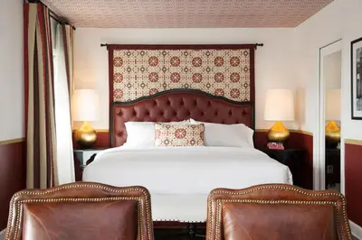 a bedroom with a large bed and two chairs at Casa Laguna Hotel & Spa in Laguna Beach