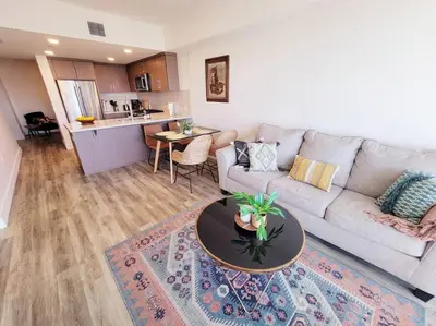 a living room with a couch and a table at Bayviews Lux One-bedroom Apartment 1min to Petco Park Convention Center Gaslamp Pool, Hot Tub in San Diego