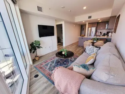 a living room with a large couch and a kitchen at Bayviews Lux One-bedroom Apartment 1min to Petco Park Convention Center Gaslamp Pool, Hot Tub in San Diego