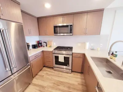 a kitchen with stainless steel appliances and wooden cabinets at Bayviews Lux One-bedroom Apartment 1min to Petco Park Convention Center Gaslamp Pool, Hot Tub in San Diego