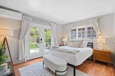 a white bedroom with a bed and windows at Restful Retreat - Vibrant - Tranquil Yard in San Diego