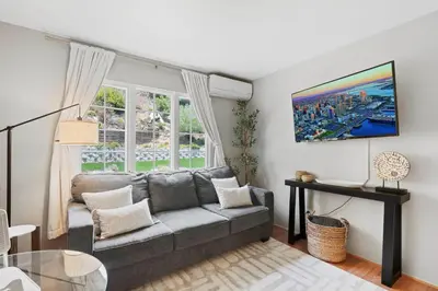 a living room with a couch and a window at Restful Retreat - Vibrant - Tranquil Yard in San Diego