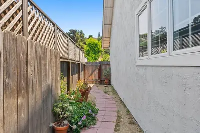 a garden path next to a fence with potted plants at Restful Retreat - Vibrant - Tranquil Yard in San Diego