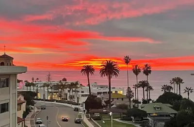 a sunset over a city with palm trees and a street at Restful Retreat - Vibrant - Tranquil Yard in San Diego