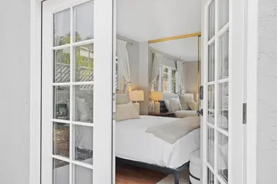 a bedroom with a bed and a room with windows at Restful Retreat - Vibrant - Tranquil Yard in San Diego