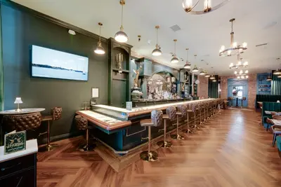 a bar in a restaurant with bar stools at The Beau Hotel Downtown San Diego Gaslamp Quarter in San Diego