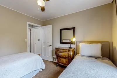 a bedroom with two beds and a dresser with a mirror at Playa Del Sur Getaway La Jolla in San Diego