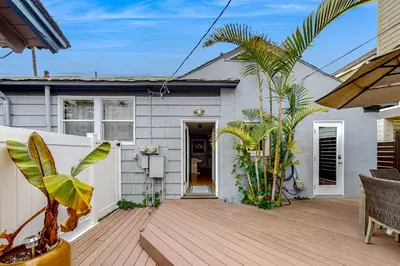 a home with a wooden deck and a house at Playa Del Sur Getaway La Jolla in San Diego