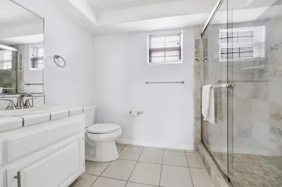 a white bathroom with a toilet and a shower at 1404 W Oceanfront B in Newport Beach