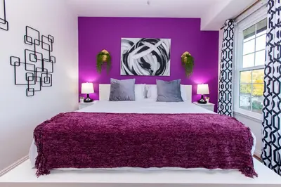 a purple bedroom with a large bed and purple walls at Amethyst Hearth - Family Spa Serenity, Zoo, Beach, Disneyland, Legoland in Vista