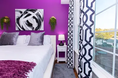 a purple bedroom with a bed and a window at Amethyst Hearth - Family Spa Serenity, Zoo, Beach, Disneyland, Legoland in Vista