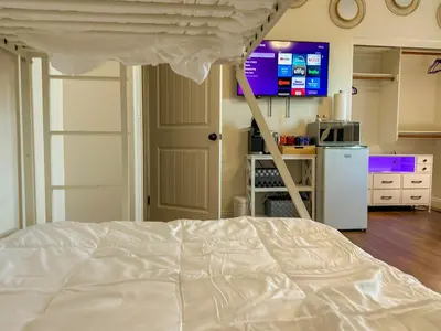 a white bed in a room with a kitchen at Amethyst Hearth - Family Spa Serenity, Zoo, Beach, Disneyland, Legoland in Vista