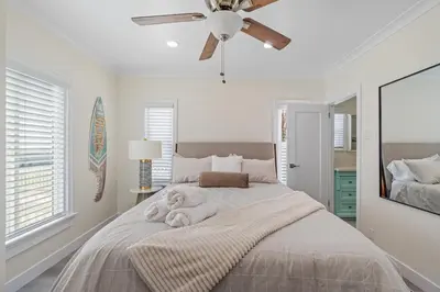 a bedroom with a bed with a ceiling fan at Carlsbad Blvd Villa in Carlsbad