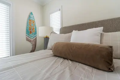 a white bedroom with a large bed with white pillows at Carlsbad Blvd Villa in Carlsbad