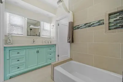 a bathroom with a tub and a sink and a mirror at Carlsbad Blvd Villa in Carlsbad