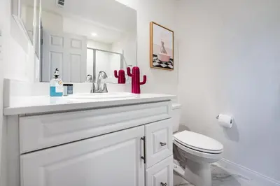 a white bathroom with a sink and a toilet at Brand New Stunning 4BR Townhome in Lemon Grove