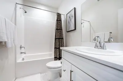a white bathroom with a sink and a toilet at Brand New Stunning 4BR Townhome in Lemon Grove