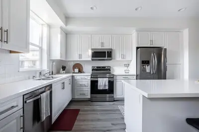 a kitchen with white cabinets and stainless steel appliances at Brand New Stunning 4BR Townhome in Lemon Grove