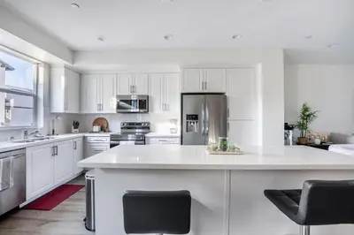 a kitchen with white cabinets and a large kitchen island at Brand New Stunning 4BR Townhome in Lemon Grove