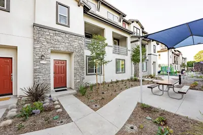 a patio with a table and an umbrella in front of a building at Brand New Stunning 4BR Townhome in Lemon Grove