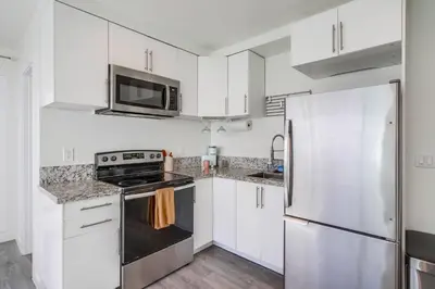 a kitchen with white cabinets and a stainless steel refrigerator at Studio Verde- Free Parking, Central in San Diego