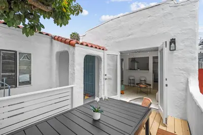 a patio with a wooden table and a house at Urban Spanish Bungalow in San Diego
