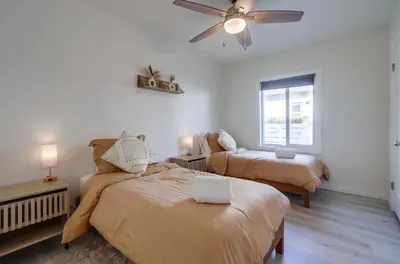a bedroom with two beds and a ceiling fan at Urban Spanish Bungalow in San Diego