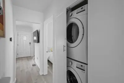 a white laundry room with a washer and dryer at Urban Spanish Bungalow in San Diego