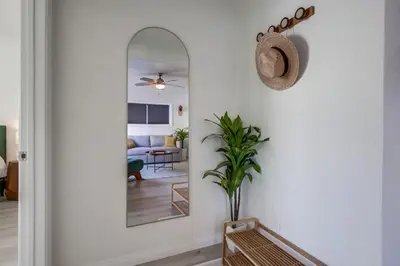 a hallway with a mirror and a living room at Urban Spanish Bungalow in San Diego